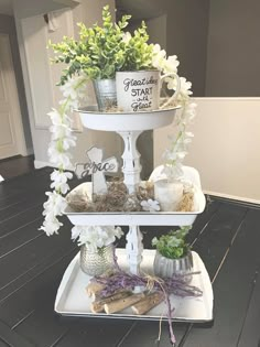 three tiered tray with flowers and candles on it