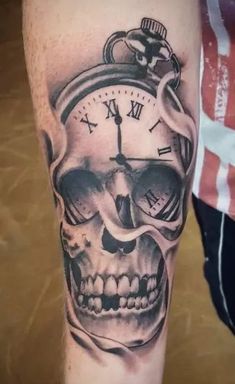 a skull with a clock tattoo on its leg