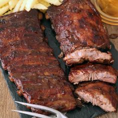 barbecue ribs and french fries on a cutting board