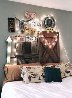 a bed with pillows and lights on the headboard is decorated with old license plates