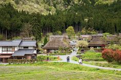 two people walking down a path in front of some houses