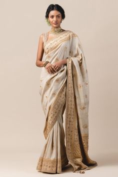 Ivory saree with floral motif zardozi embroidery, tassel pallu and crystal border. Paired with hand worked grid pattern blouse.
Component: 2
Embroidered
Sleeve Length: Sleeveless
Fabric:  Tussar Brocade, Tulle
Color: White
Cutout back
Bead tassel
Tassel pallu
Cutwork detail
Note: The sari is in handwoven moonga silk fabric. The motif design will vary slightly from the image. - Aza Fashions Tarun Tahiliani Saree, Engagement Saree, Brocade Saree, Raw Silk Lehenga, Couple Wedding Dress, Silk Tulle, Tarun Tahiliani, Elegant Saree, Illustration Fashion Design