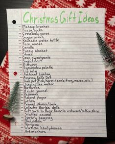 a christmas gift ideas list on top of a red and white napkin with a green tree