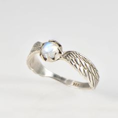 Angel wings in sterling silver with moonstone. This little and delicate guardian angel ring is made to remind us that we all have our own guardian angle , in the spirit realm and in the physical. This beautiful angel wings design is ment to serve as our own little guardian , with beautiful moonstone set at the crown of the angel to give it the angelic aura it deserves. Excellent gift option for your loved ones who you like to be protected at all times :) Stone size: 5mm natural moonstone Ring width: approximately 6 mm at the widest part and 3 mm at the narrow part *Available Ring Size: 4.5-11 USA 48-65 European *Our silver rings are made from high quality solid sterling silver (925) Please feel free to contact us for any information you desire. *Don't forget to wear it with a smile :) BAND Spirit Realm, Angel Ring, Angel Wings Design, Beautiful Angel, Wings Design, The Angel, Guardian Angel, Moonstone Ring, Angel Wings