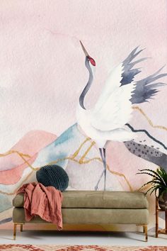 a woman sitting on a couch in front of a wall mural with a crane painted on it