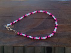 a white black and pink seed bead anklet. Cute and beachy themed Casual Pink Handmade Anklet, Pink Round Beads Anklets For Festival, Pink Tiny Beads Anklets For Summer, Pink Anklets With Tiny Beads For Summer, Casual Pink Beaded Chain Bracelets, Bead Bracelets Designs, Seed Bead Anklet, Pink Waves, Beaded Items