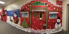 an office decorated for christmas with santa's house and snowman on the door