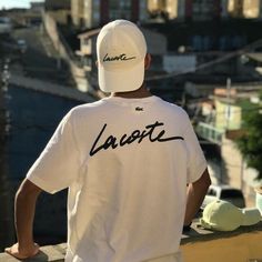 a man wearing a white hat and t - shirt with the word lacost written on it