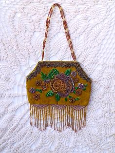 "Darling, glass beaded, embroidered, fringed handbag. Soft, taupe velvet, hand embroidered with iridescent beads of copper, green, purple, gold and lavender. This purse also has 3 inches of lattice woven, dangle fringe in iridescent gold and lavender with 2 multi color bead handles accented with 24 clear glass bi-cone crystals. \"Unique and Lovely\" Vintage Vault Gifts" Bohemian Beaded Bags For Celebration, Vintage Beaded Bags For Festival, Vintage Bags For Festivals, Gold And Lavender, Bead Purse, Fringe Handbags, Vintage Evening Bags, Boho Garden, Purse Vintage