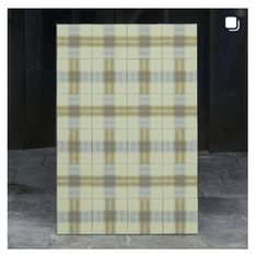 a white and yellow plaid tile wall in front of a black door