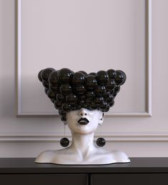 a white mannequin head with black balloons on it