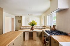 a kitchen with wooden counter tops and white walls, along with an island in the middle