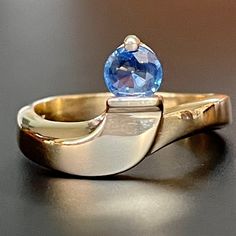 This intriguing 14K gold and natural sapphire ring features elegant lines and a stunning high quality round bright blue sapphire! The stone is very clear and free of eye visible inclusions, and is a most desirable cornflower blue! As measured in setting, the sapphire is approximately.40Ct, measuring 4.9mm in diameter and 2.15mm in depth. The ring is stamped with the 14K gold purity mark, and is a size 6.5US.* The band 3mm wide at the bottom an 4.45mm at it's widest point at the top. The ring wei Elegant Yellow Gold Sapphire Ring With Tension Setting, Elegant 14k Gold Sapphire Ring With Tension Setting, 14k Gold Polished Finish Round Topaz Ring, Modern 14k Gold Sapphire Ring With Center Stone, Formal Round Sapphire Ring With Tension Setting, Polished Round Cut Sapphire Ring, Modern 14k Gold Round Sapphire Ring, Diamond Cut Sapphire Ring, Diamond Cut Round Sapphire Ring