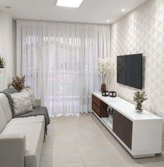 a living room with white furniture and curtains