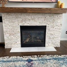 a living room with a fire place and rugs on the floor in front of it