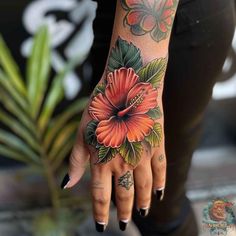 a woman's hand with tattoos on it and a flower tattooed on the palm