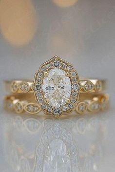 a yellow gold engagement ring with an oval cut diamond in the center