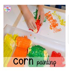 a child's hands painting with crayons on a paper plate in the shape of fish