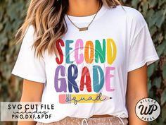 a woman wearing a white shirt with the words second grade printed on it