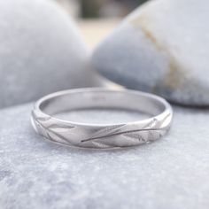 a silver ring sitting on top of a rock