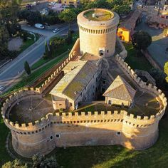 an aerial view of a castle in the middle of a town with lots of trees and buildings