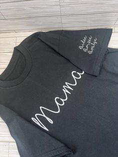 Mama Personalized Embroidered Crewneck T-shirt, Mama Sweatshirt, Mama Gift, Crewneck T-shirt, Gift for Mom, Mom Appreciation, Mama T-shirt Unisex, Mother's Day Gift These are Unisex sizing. If you would like it more fitted please size down there will be no returns or exchanges. Please select color, size of T-shirt and don't forget to write child's name down (up to x4 names on left sleeve). All sales are final due to customization of product. Will ship USPS unless requested otherwise. Colors may differ slightly from appearance on screen. Black Cotton T-shirt With Embroidered Logo, Black Cotton Tops With Embroidered Logo, Black Crew Neck Top With Embroidered Logo, Black Embroidered Cotton Shirt, Cotton T-shirt With Embroidered Text, Crew Neck, Casual Crew Neck T-shirt With Custom Embroidery, Cotton T-shirt With Embroidered Graphics, Crew Neck, Short Sleeve Cotton Tops With Embroidered Logo, Basic Short Sleeve Top With Embroidered Logo