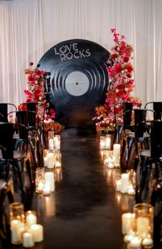 a long table with candles and flowers on it in front of a large vinyl record