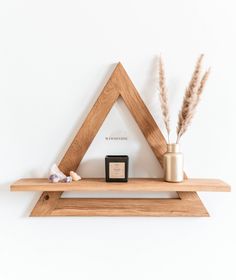 a wooden shelf with a candle and some plants on it