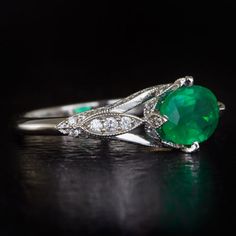 Featured here is a stunning vintage inspired emerald and diamond ring with timeless style and class! Prong set in the center of this ring is a slightly larger than 1 carat natural emerald with lovely saturation! The natural earth-mined emerald adds a wonderful pop of color to this ring. The rich emerald is complemented by 54 fully faceted round cut diamonds which are all white and clean to the naked eye. The small diamonds have great sparkle as well and look even better in person. The ring is ma Gia Certified Green Diamond Ring In Vintage Style, Classic Emerald Diamond Ring With Accent Stones, Vintage Green Emerald Ring Gia Certified, Gia Certified Oval Emerald Ring In Art Deco Style, Classic Diamond Ring With Accent Stones For May Birthstone, Vintage White Gold Oval Emerald Ring, Vintage Emerald Ring With Prong Setting, Vintage Oval White Gold Emerald Ring, Vintage Emerald Ring With Brilliant Cut For May Birthstone