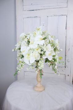 a vase filled with white flowers on top of a table