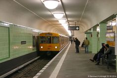 people are waiting for the train at the subway station as it pulls up to the platform