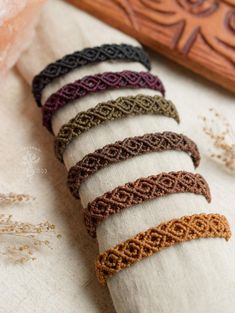 six pieces of knitted bracelets sitting on top of a white cloth covered table