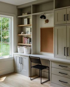 a chair sitting in front of a window on top of a wooden floor next to cabinets