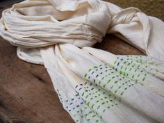 a white scarf sitting on top of a wooden table