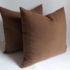 two brown pillows sitting next to each other