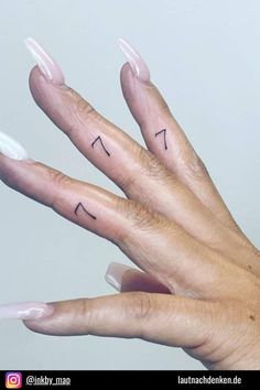 a woman's hand with two finger tattoos on her left and the other half of her fingers