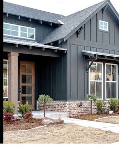 a gray house with red brick and white trim