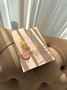 a piece of cake sitting on top of a brown couch next to a white curtain