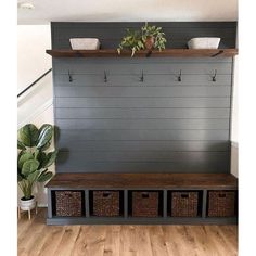 an entryway bench with baskets and plants on the top, next to a wall mounted coat rack