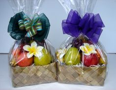 two bags filled with apples and flowers on top of a table next to each other