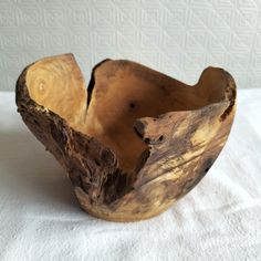 a wooden bowl sitting on top of a white cloth