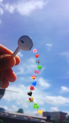 a person holding a spoon with hearts and flowers on it in front of a blue sky