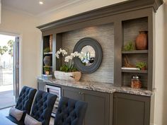 the dining room table is set with blue chairs, and there are vases on top of it