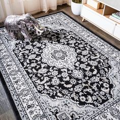 an elephant statue sitting on top of a black and white rug