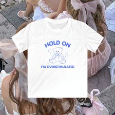 90s style baby tee with ' Hold on, I'm overstimulated ' slogan graphic design with teddy bear design Please read the full product description below before ordering  🎀  QUALITY & SUSTAINABILITY 🎀 * Our tees are made with high quality, 100% ringspun cotton for a soft feel and perfect fit. Our fine quality designs are digitally printed with premium ink - our tees are built to last!  * In order to reduce waste, all of our items are made to order * Our t-shirt manufacturer is certified fair trade a Y2k Streetwear T-shirt With Funny Text, White Y2k T-shirt With Funny Text, Y2k White T-shirt With Funny Text, Slogan Graphic Design, Baby Tees 90s, Aesthetic Funny, Style Tshirt, Teddy Bear Design, Funny Tshirt