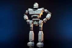 a lego robot standing in front of a black background