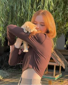 a woman holding a small kitten in her arms