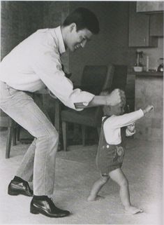 an old photo of a man playing with a child