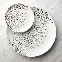 two white plates with gold dots on them