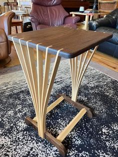 a wooden table sitting on top of a rug in a living room next to a leather chair